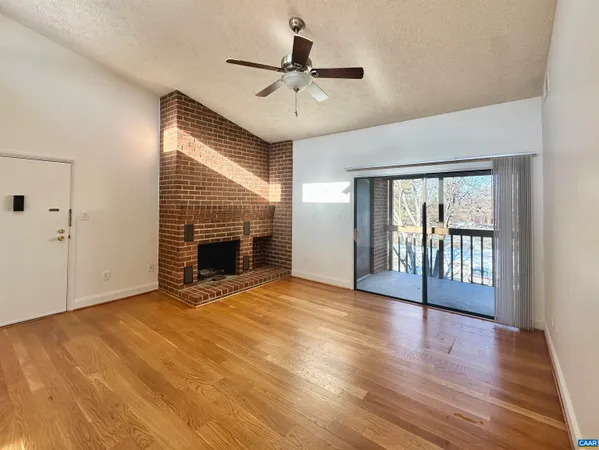 wooden floor fireplace and windows in an empty room