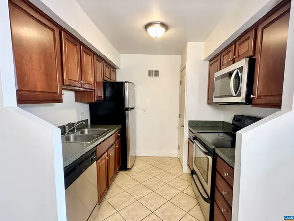 a kitchen with granite countertop a refrigerator stove and sink