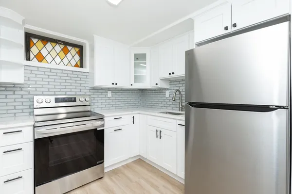 a kitchen with stainless steel appliances a refrigerator sink and cabinets