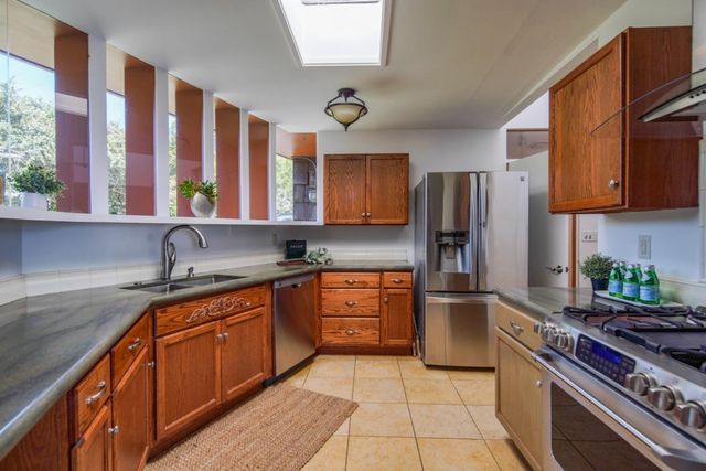 a kitchen with stainless steel appliances granite countertop a refrigerator and a stove top oven