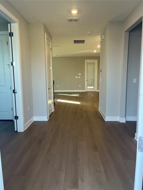 3012 Polaris Drive St. Cloud, FL 34771 - Photo 5 of 21 an empty room with wooden floor and mirror