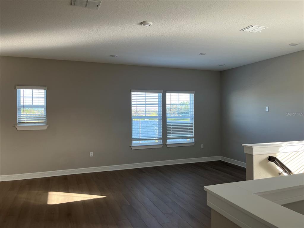 3012 Polaris Drive St. Cloud, FL 34771 - Photo 10 of 21 an empty room with wooden floor and windows
