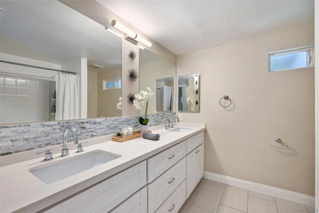 a bathroom with double sink and a mirror
