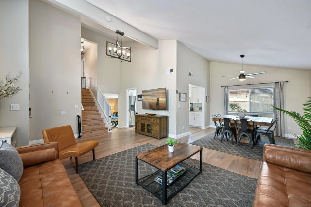 a living room with furniture and a dining table with wooden floor