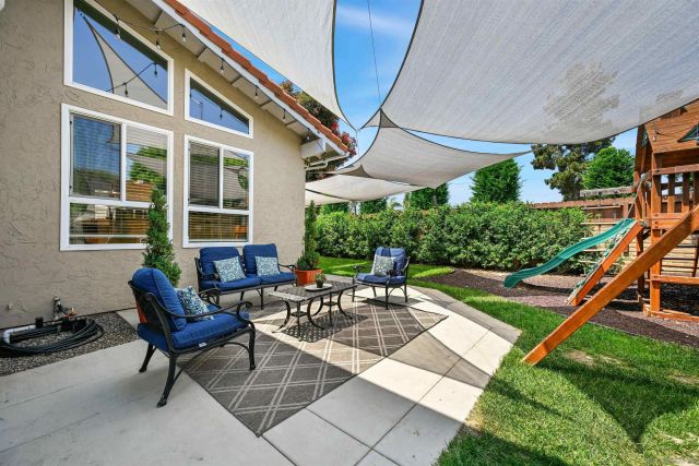 a view of a house with backyard sitting area and furniture
