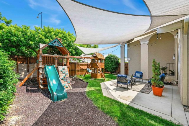 a view of a patio with chairs and table in a yard
