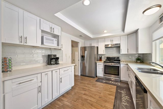 a kitchen with white cabinets and stainless steel appliances