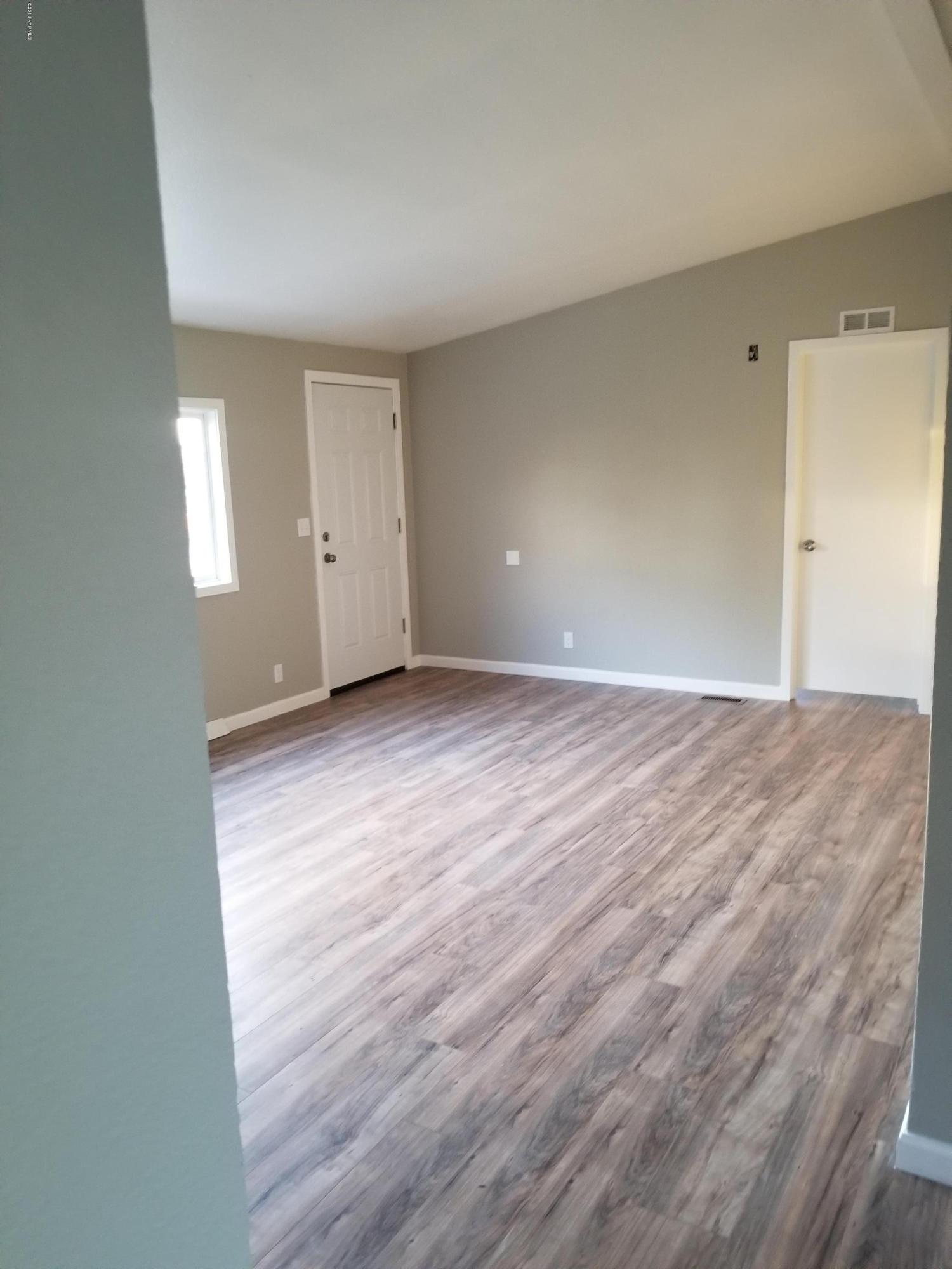 1033 Rader Road Sunnyside, WA 98944 - Photo 2 of 12 a view of an empty room with wooden floor and a window