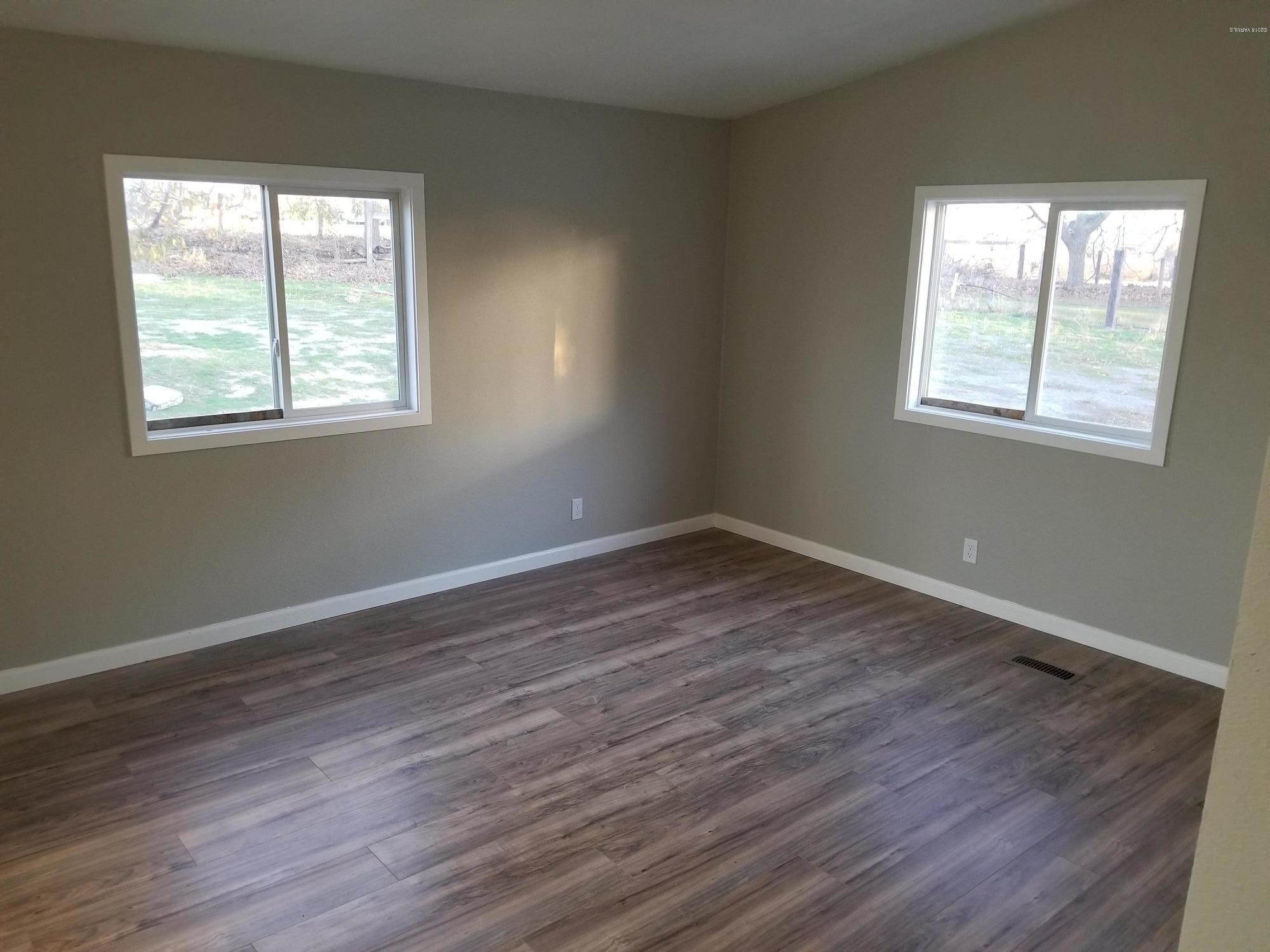 1033 Rader Road Sunnyside, WA 98944 - Photo 5 of 12 a view of an empty room with wooden floor and a window