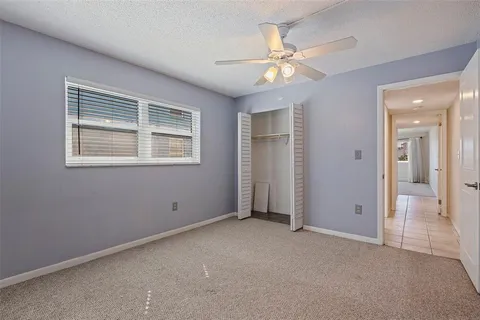an empty room with fan and windows