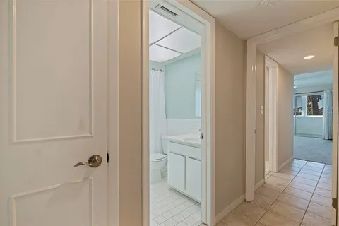 a view of a hallway with closet and a bathroom
