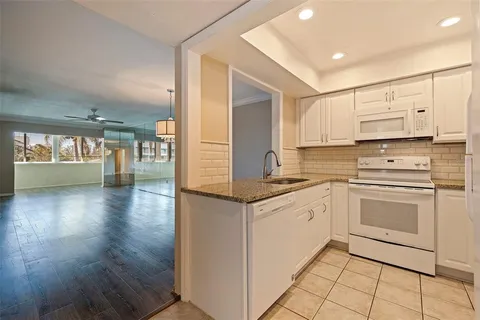 a kitchen with stainless steel appliances granite countertop a sink and cabinets