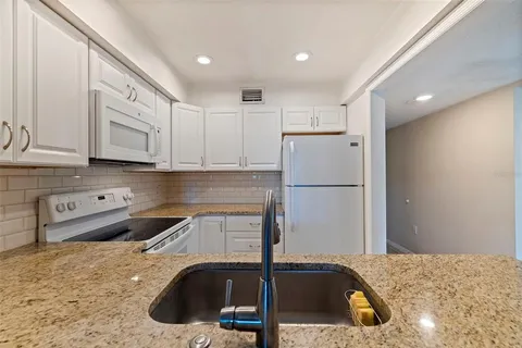 a kitchen with a sink a refrigerator and cabinets