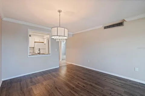 a view of a room with wooden floor chandelier and window