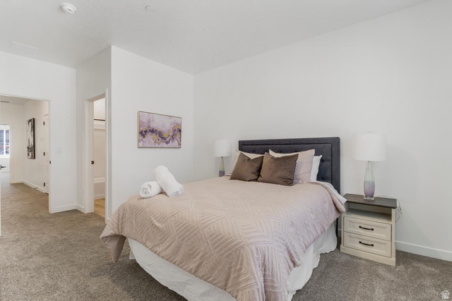 1705 Ripple Rock Drive, Unit 3017 Washington, UT 84780 - Photo 10 of 22 Carpeted bedroom featuring white walls and a gray upholstered headboard