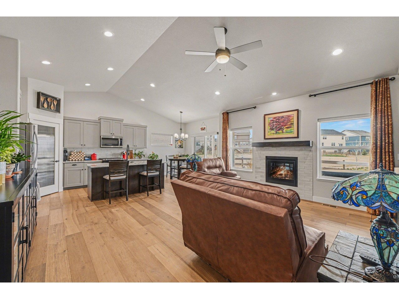 6309 2nd Street Greeley, CO 80634 - Photo 5 of 33 a living room with furniture a fireplace and kitchen view
