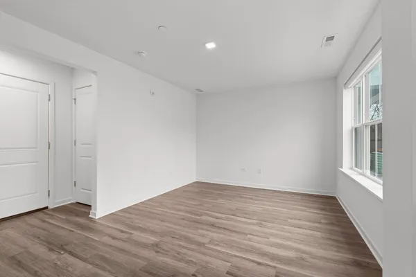 a view of an empty room with wooden floor
