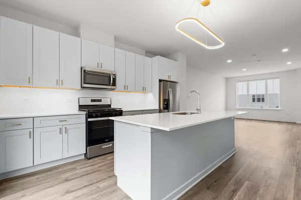 a kitchen with kitchen island a sink stainless steel appliances and cabinets