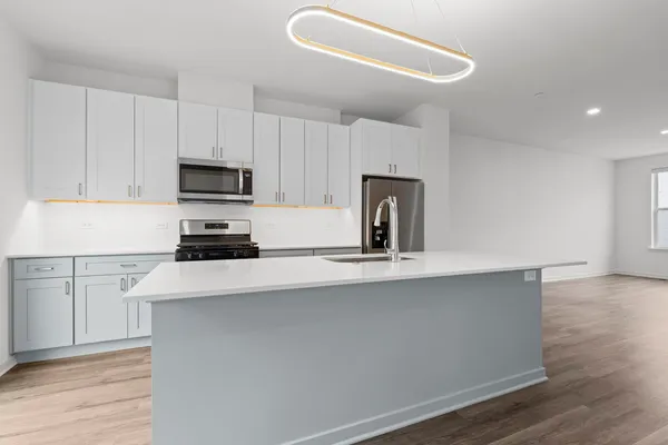 a kitchen with sink a microwave and cabinets