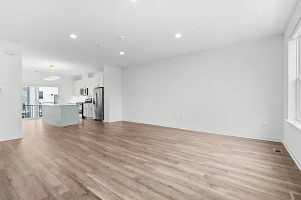 a view of empty room with wooden floor