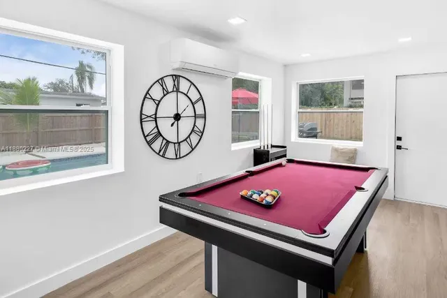 a kitchen with stainless steel appliances a sink a stove a refrigerator cabinets and a chairs