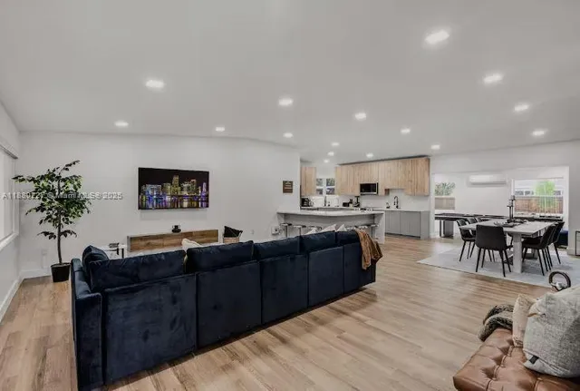 a living room with furniture a flat screen tv and a large window