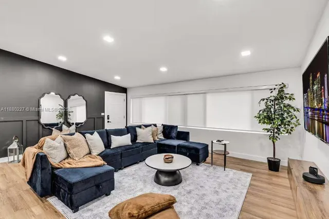 a living room with furniture kitchen view and a table