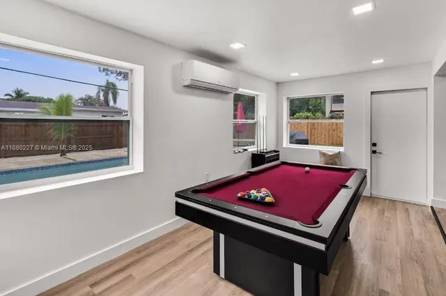 a room with pool table and windows
