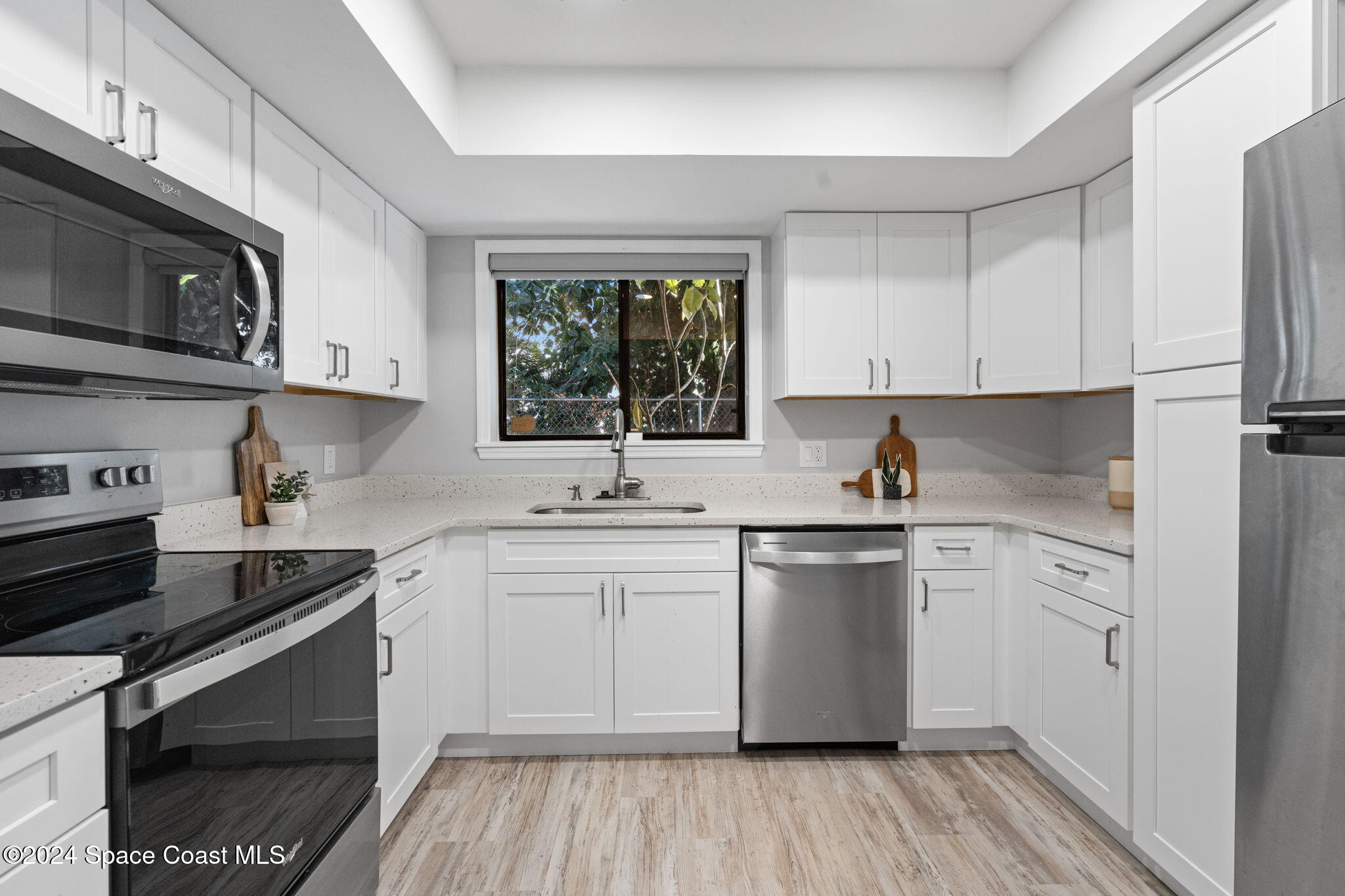654 Cedar Side Circle Northeast Palm Bay, FL 32905 - Photo 15 of 35 a kitchen with stainless steel appliances granite countertop a stove a sink dishwasher and a microwave oven with wooden cabinets