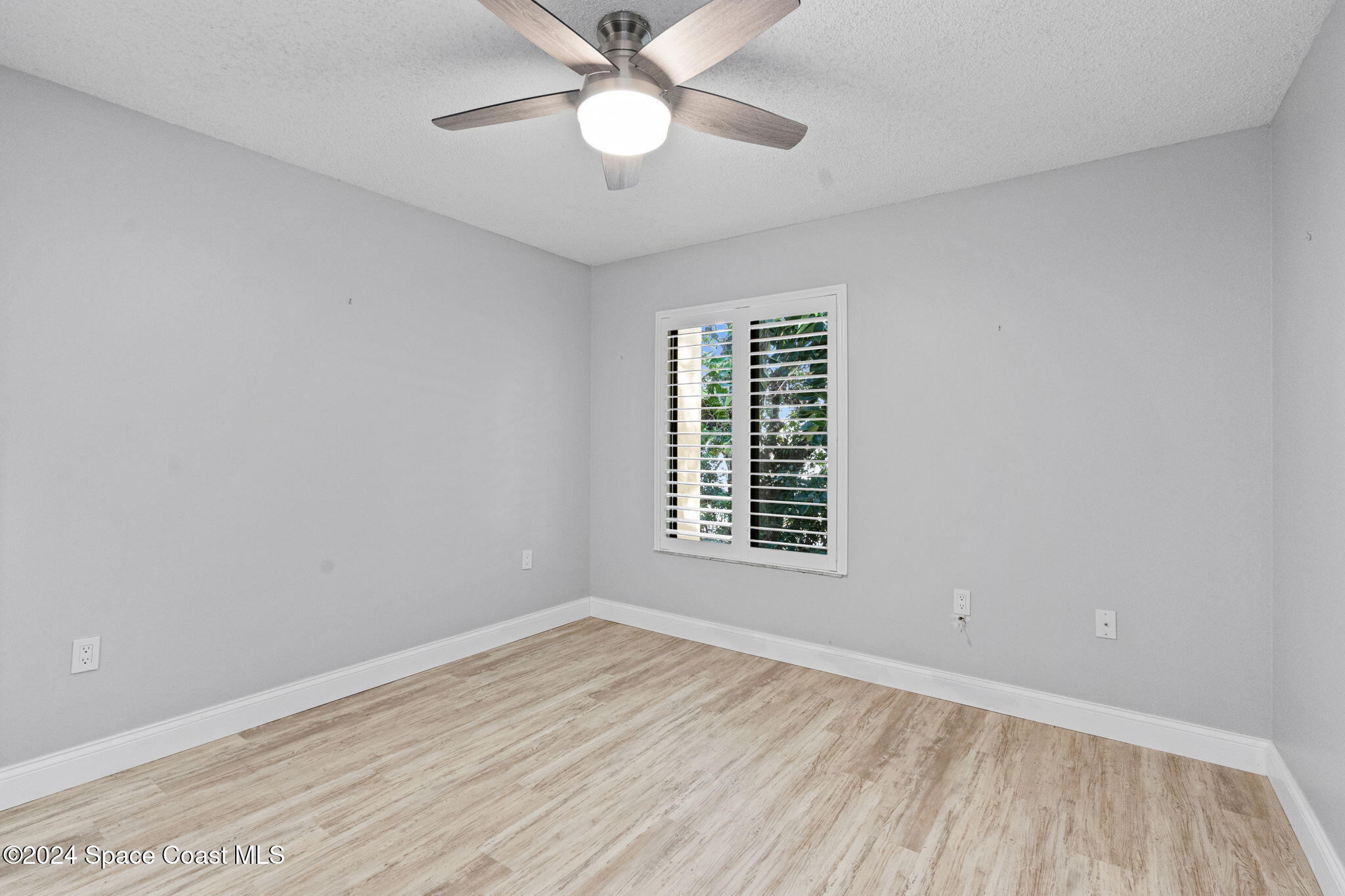 654 Cedar Side Circle Northeast Palm Bay, FL 32905 - Photo 17 of 35 an empty room with a window and ceiling fan