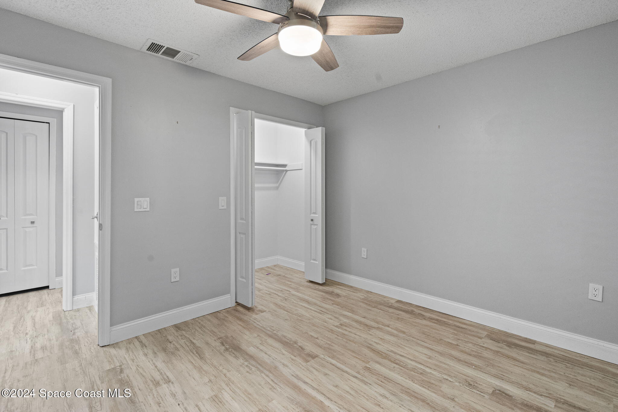654 Cedar Side Circle Northeast Palm Bay, FL 32905 - Photo 19 of 35 a view of an empty room with wooden floor