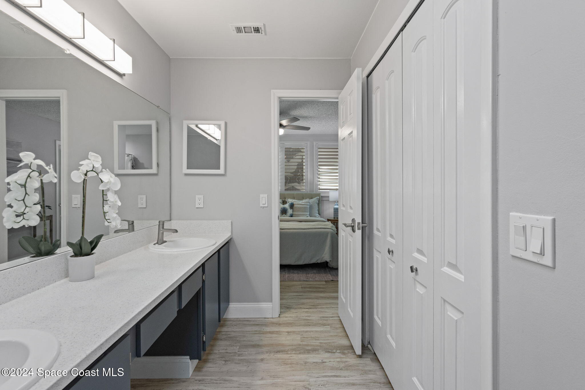 654 Cedar Side Circle Northeast Palm Bay, FL 32905 - Photo 26 of 35 a en suite bathroom with a double vanity sink a mirror and a shower