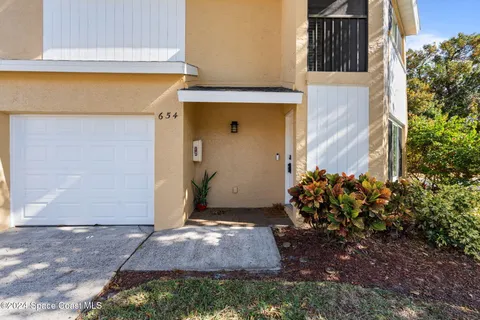a view of a front door and flowers