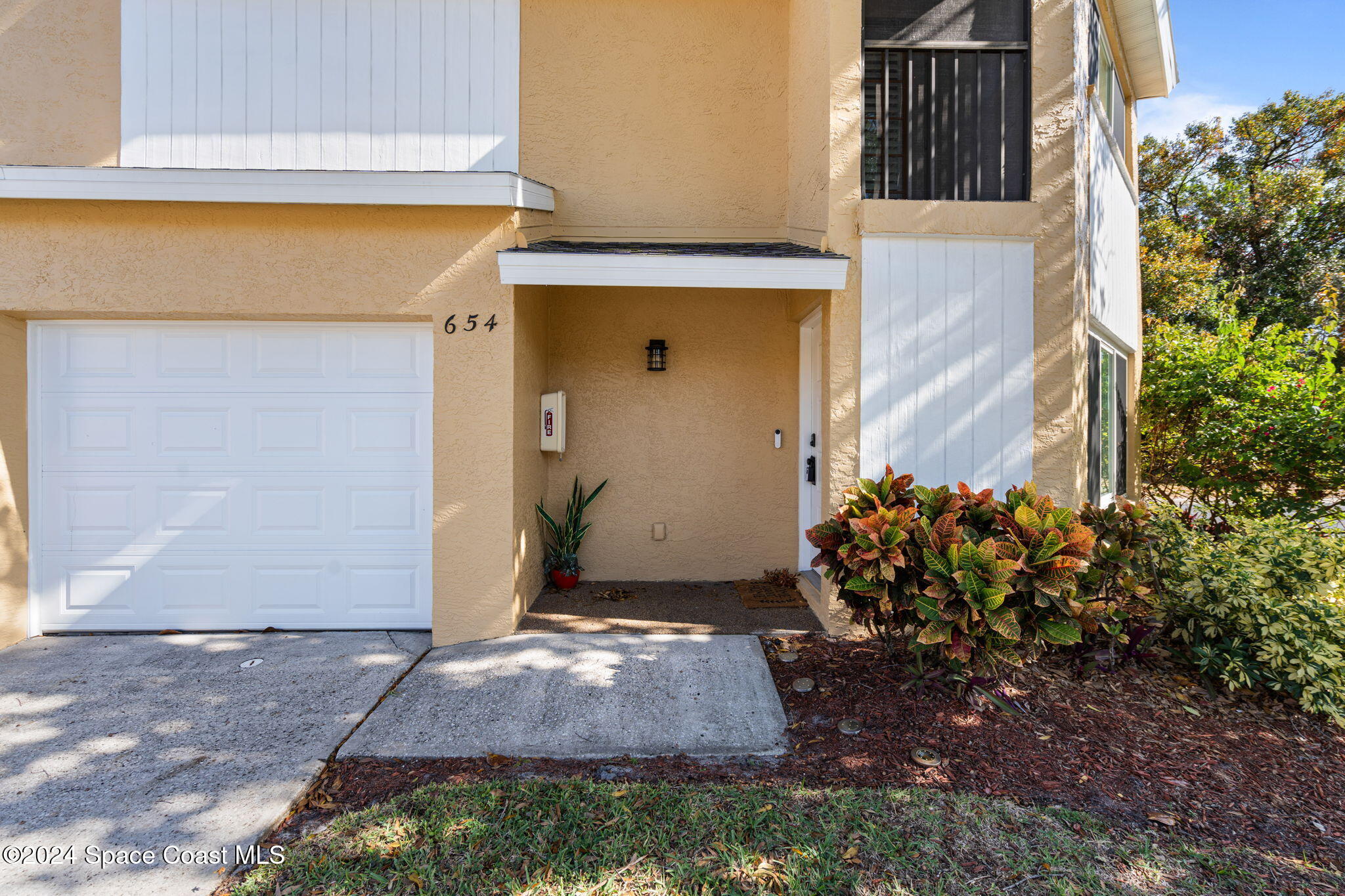 654 Cedar Side Circle Northeast Palm Bay, FL 32905 - Photo 4 of 35 a view of a front door and flowers