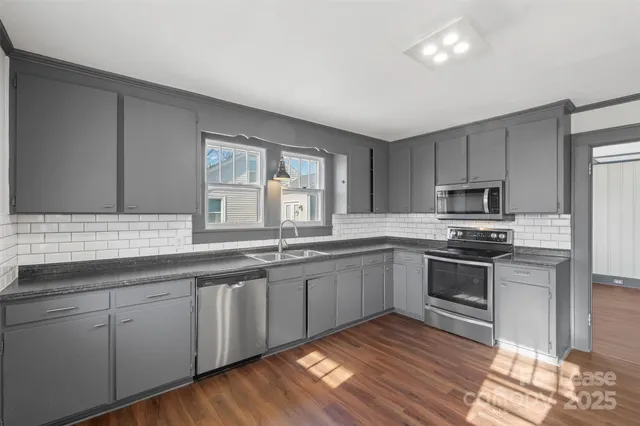 a kitchen with stainless steel appliances granite countertop a sink and stove top oven