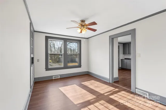 an empty room with a ceiling fan and a window