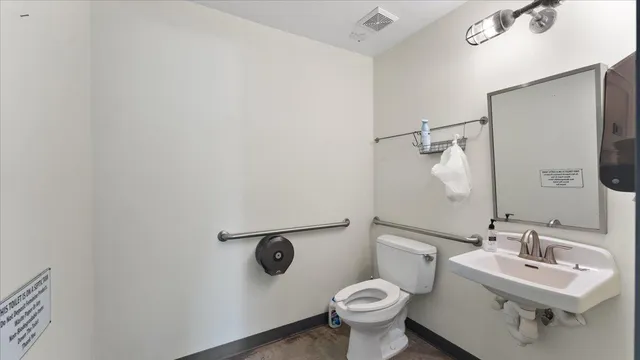 a bathroom with a toilet sink and mirror