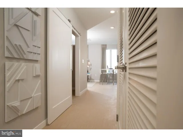 a bedroom with a bed and lamp on dresser