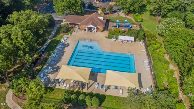 an aerial view of residential houses with outdoor space and trees all around