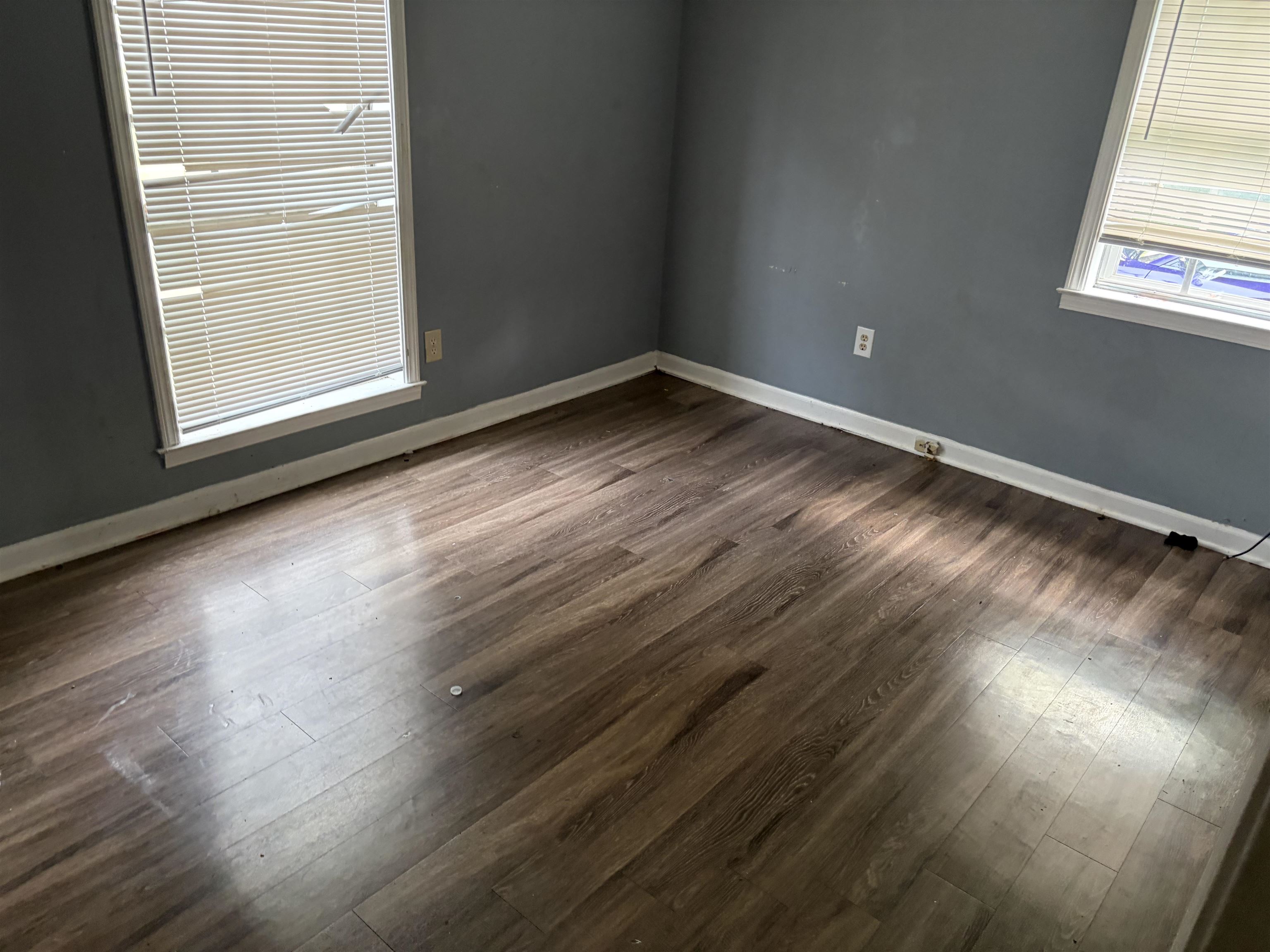 4993 Cedar View Road Memphis, TN 38118 - Photo 12 of 23 Room featuring wood-finish flooring, two window openings with blinds, white trim, and light gray wall paint