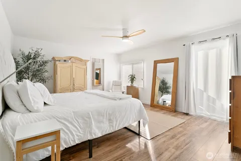 a bedroom with a bed mirror and window