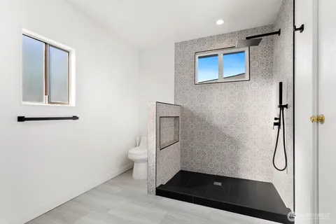 a bathroom with a granite countertop sink toilet and shower