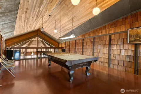 a roof deck with table and chairs with wooden floor