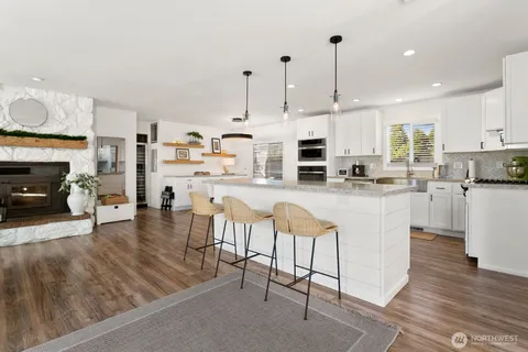 a kitchen with stainless steel appliances kitchen island granite countertop a stove a sink a oven and a refrigerator