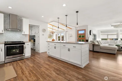 a large kitchen with cabinets wooden floor and a sink