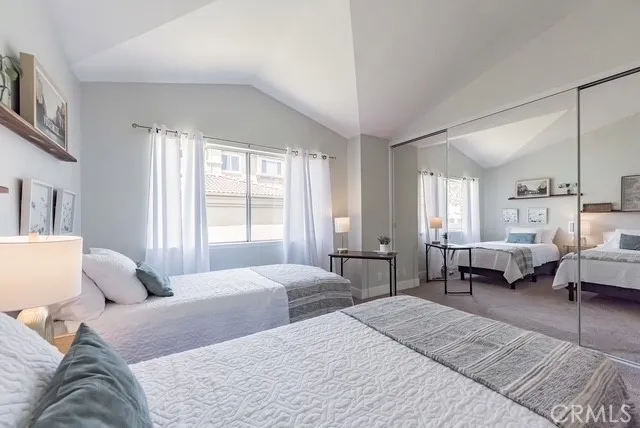 a bedroom with a bed couch and large windows