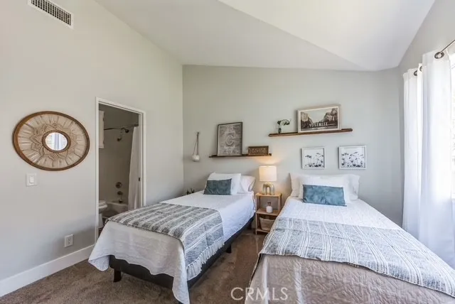 a bedroom with a bed and painting on the wall