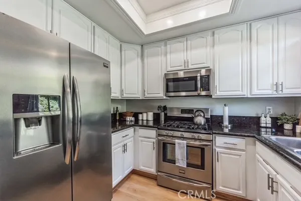 a kitchen with stainless steel appliances granite countertop a refrigerator stove and microwave