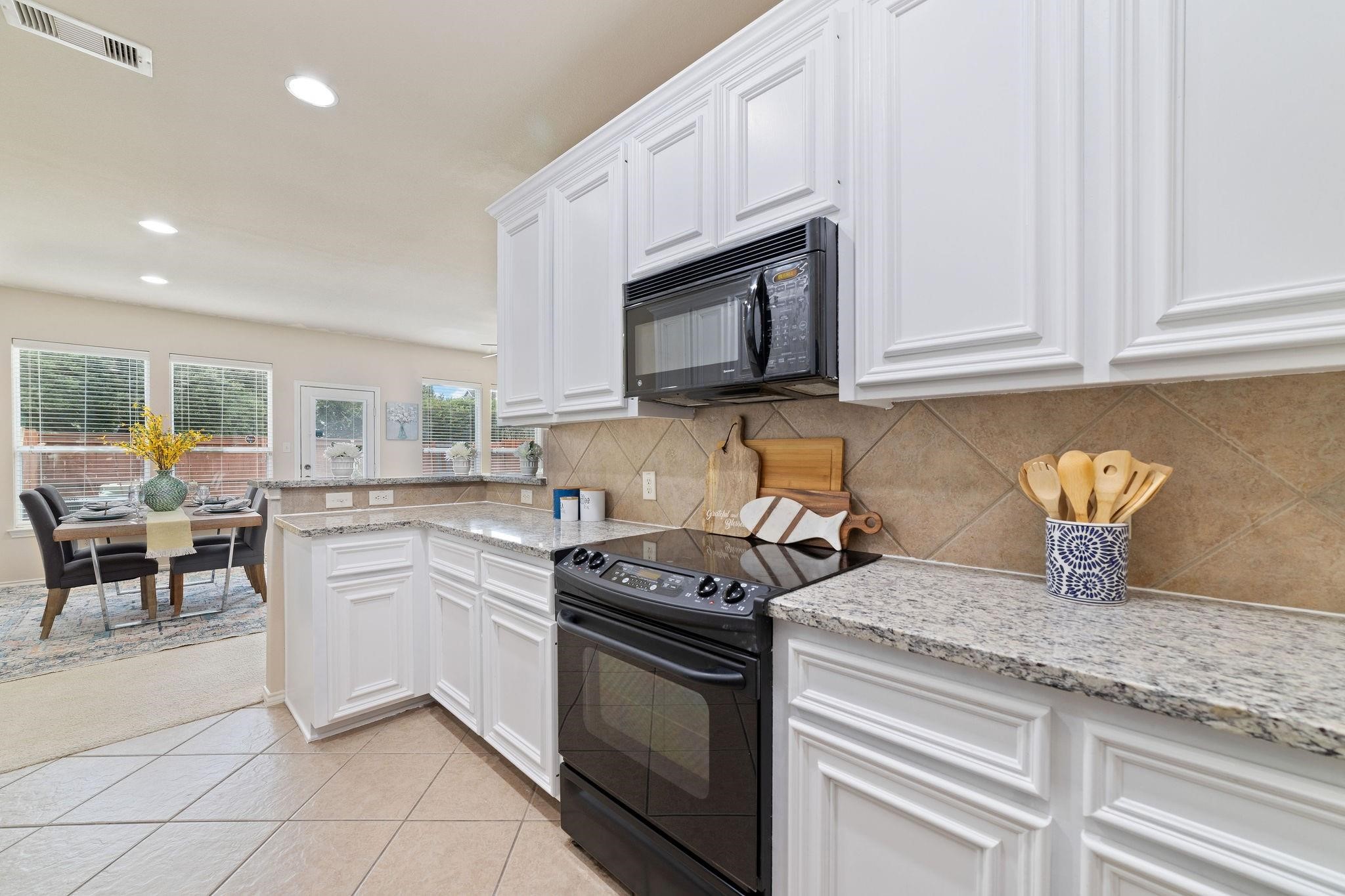 14923 Tuttle Point Drive Houston, TX 77082 - Photo 11 of 24 a kitchen with granite countertop white cabinets and stainless steel appliances