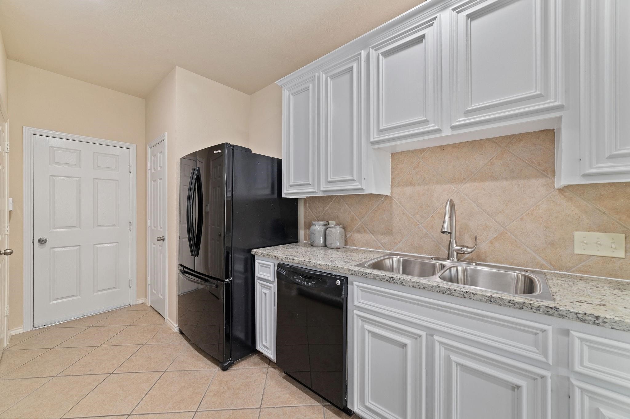 14923 Tuttle Point Drive Houston, TX 77082 - Photo 13 of 24 a kitchen with granite countertop a refrigerator sink and cabinets